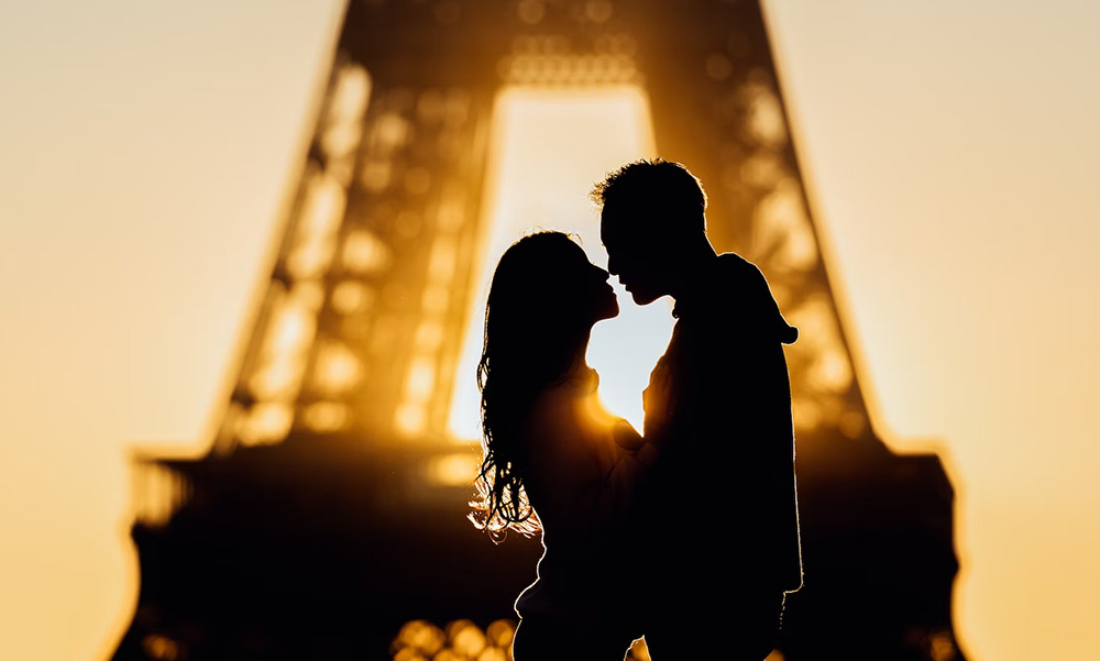 couple kissing in front of eiffel tower